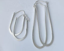 Load image into Gallery viewer, Pair of silver hoop earrings on a light gray background