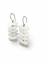 Load image into Gallery viewer, Pair of earrings with stacked white and silver disc design on a white background
