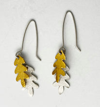 Load image into Gallery viewer, Pair of earrings with gold and silver leaf designs on a light gray background
